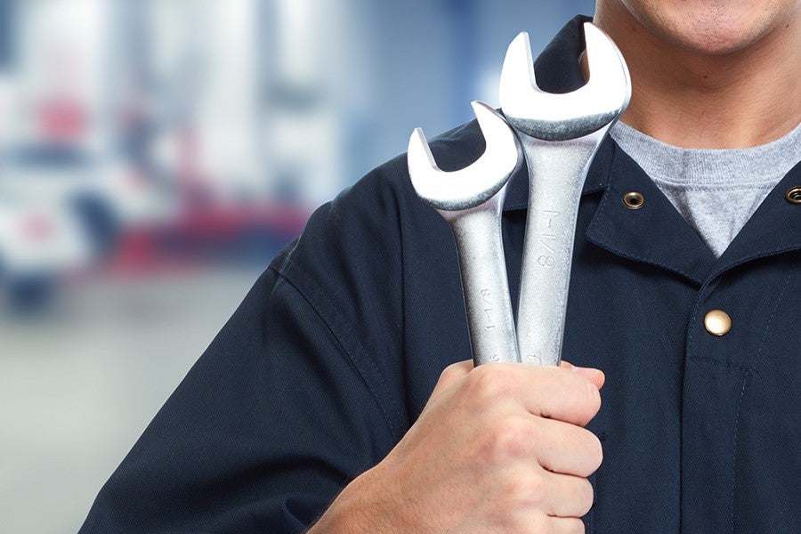 Service tech holding wrenches