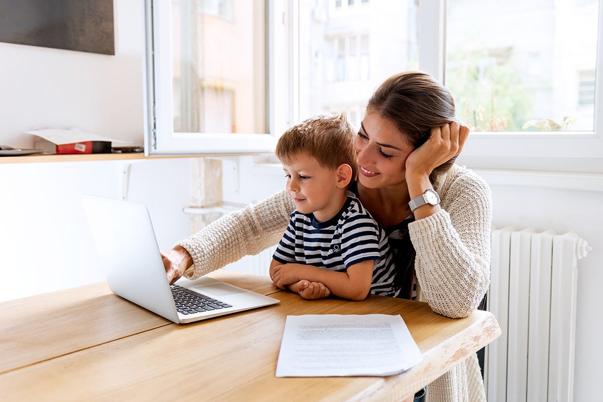 Mother and son sitting at a laptop together